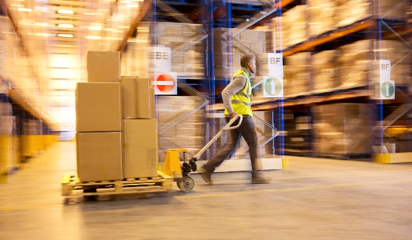 Packed boxes being taken for loading on a pallet jack.